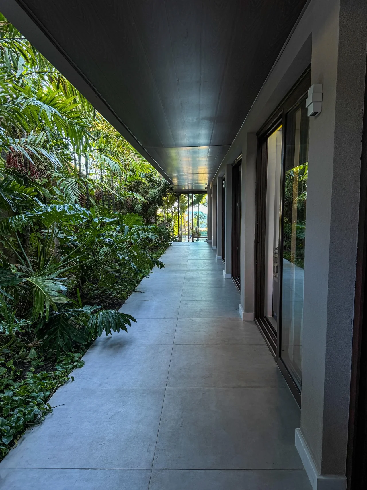 Jardim lateral junto aos cômodos de uma residência de praia.