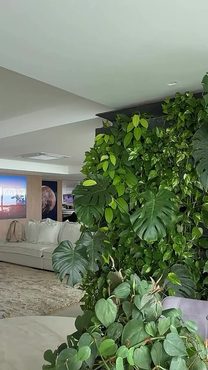 Jardim vertical integrado a uma sala de estar com sofá claro